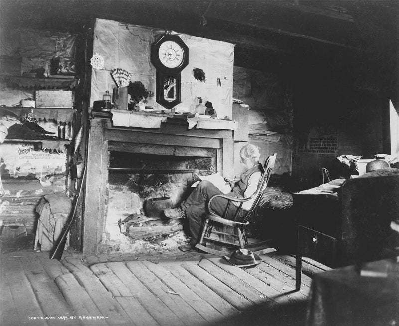 Eldery Man Seated in front of a Fireplace