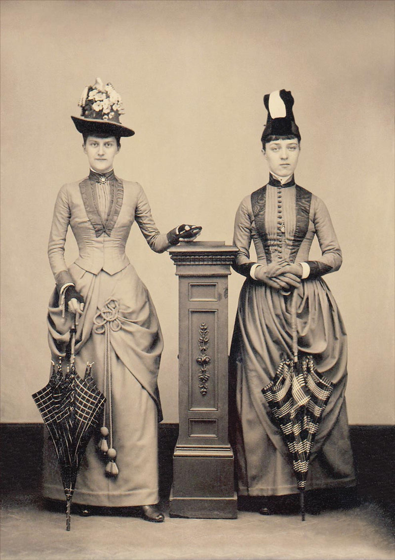 Studio Portrait of Two Women Holding Folded Parasols